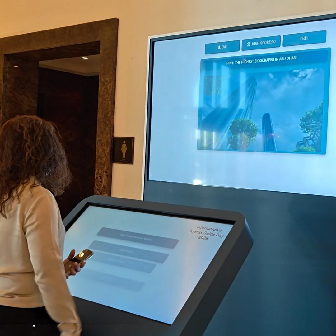 Multi-screen interactive UAE landmark guessing game display with custom branded interface for immersive event activation and digital tourism engagement.